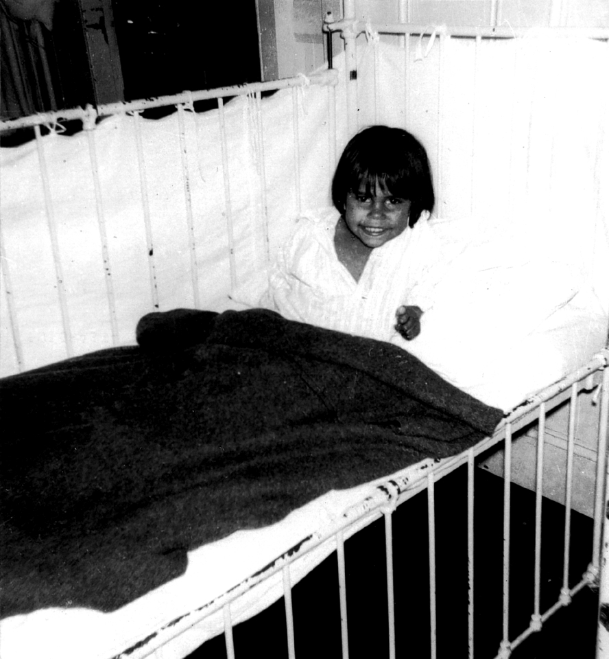 Child in bed at Cherbourg Hospital c1961